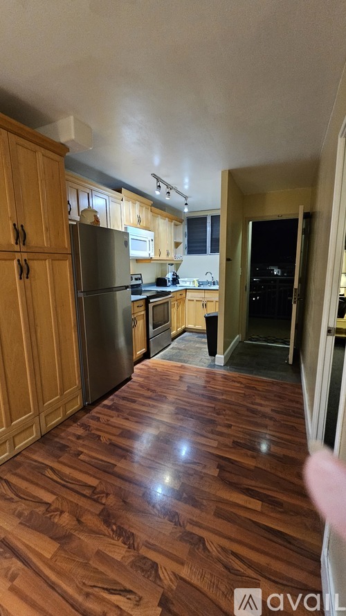 A kitchen with wooden cabinets and a refrigerator.