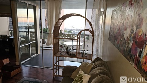 A living room with a couch and a chair with a view of the city.