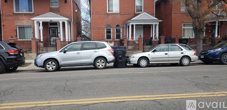 A silver car is parked on the side of the street.