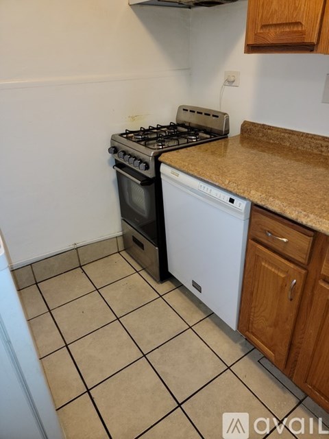 A kitchen with a black stove and white dishwasher.