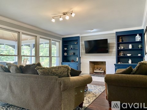 A living room with a fireplace and a television on the wall.