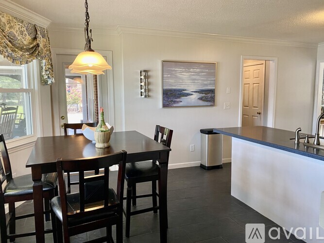 A dining room with a wooden table and chairs.
