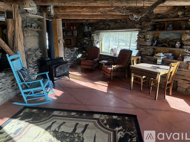 A room with a stone fireplace and wooden furniture.