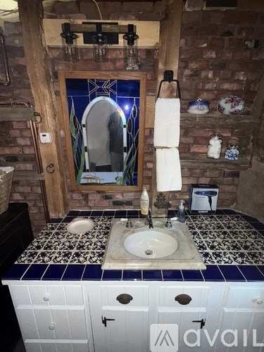 A bathroom with a white sink and a mirror.