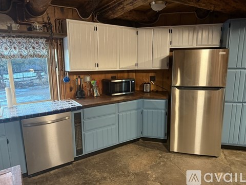 A kitchen with a stainless steel refrigerator and cabinets.