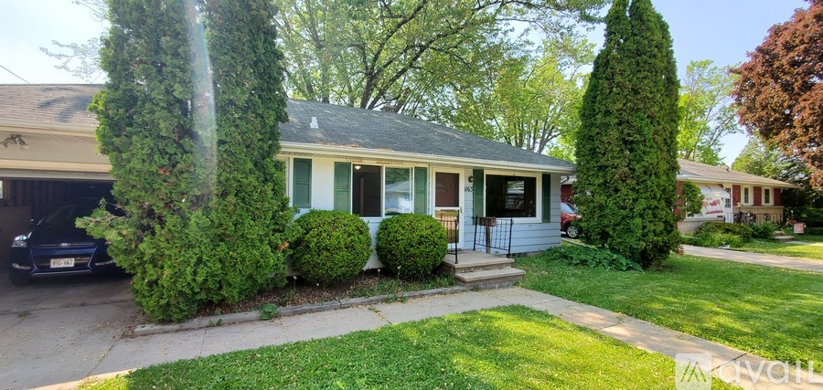 A small house with a green lawn in front.