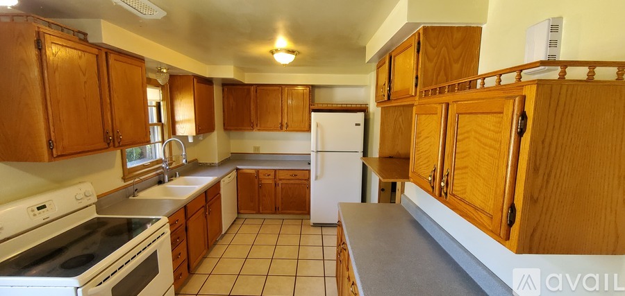 A kitchen with wooden cabinets and a white refrigerator.