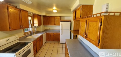 A kitchen with wooden cabinets and a white refrigerator.