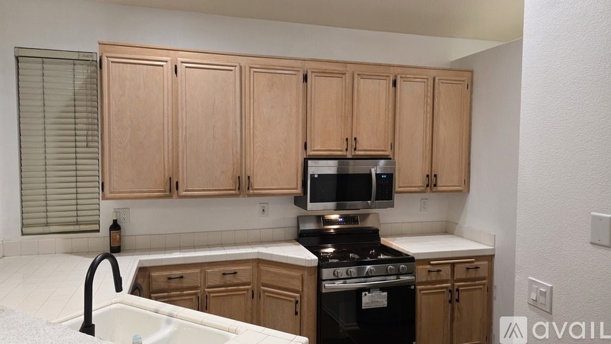 A kitchen with wooden cabinets and a black stove top oven.
