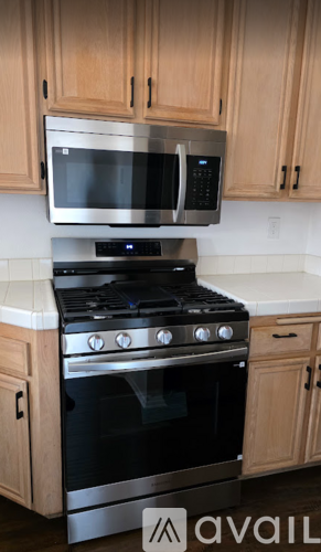 A kitchen with a stove and microwave above it.