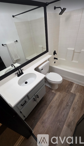 A bathroom with a toilet, sink and bathtub.