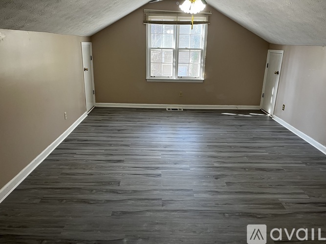 A room with wooden flooring and a window.