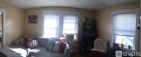 A living room with a grey couch and a white chair.