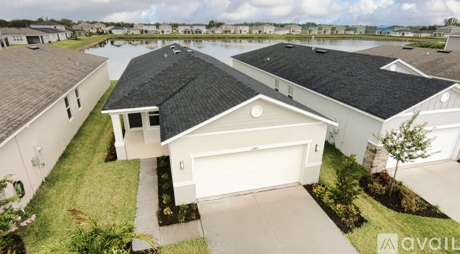 A house with a black roof and a white garage door is for sale.