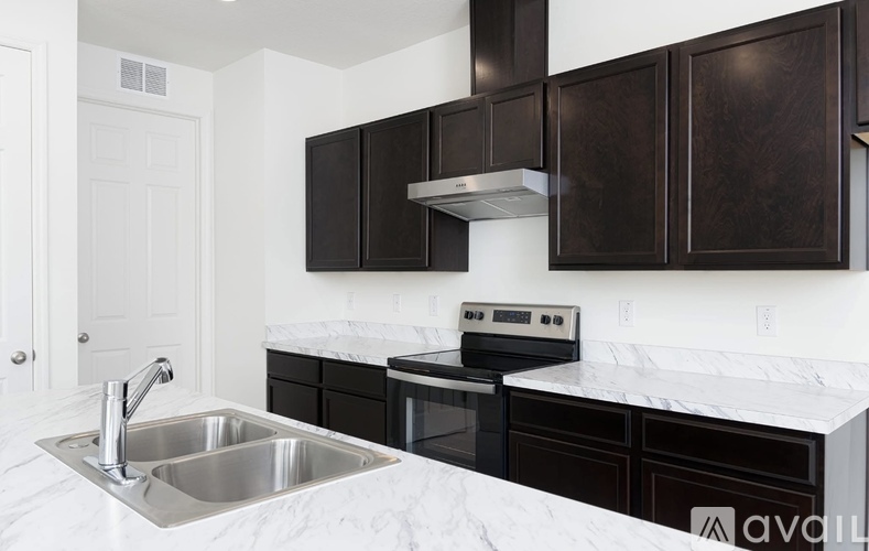 A kitchen with a sink and a stove top oven.