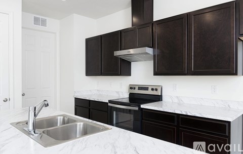 A kitchen with a sink and a stove top oven.
