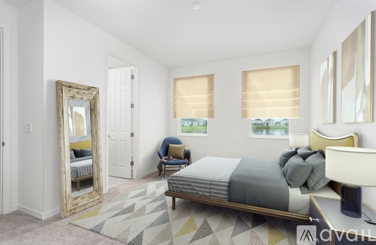A bedroom with a bed, a chair, and a large mirror.