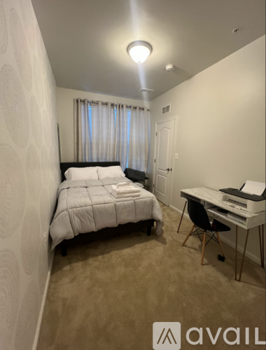 A small bedroom with a bed, desk, and chair.