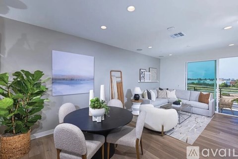 A modern living room with a dining table and chairs.