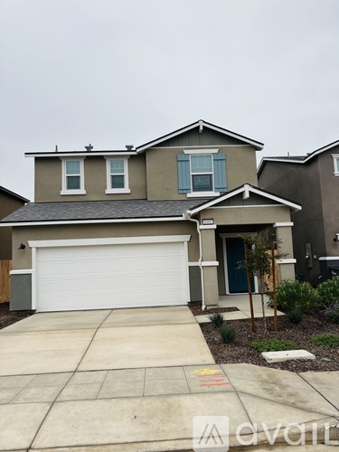 A house with a white garage door and a brown roof.