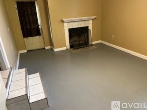A room with a fireplace and a door with a curtain.