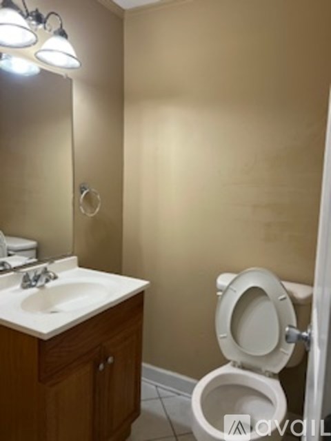 A white sink is on a wooden vanity in a bathroom.