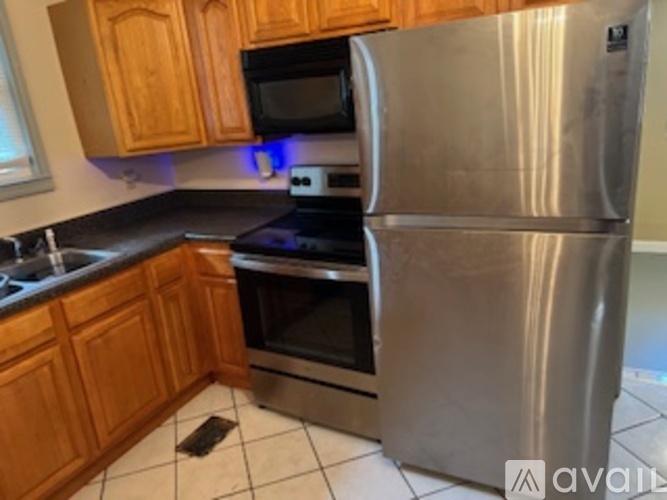A kitchen with a stainless steel refrigerator, oven, and microwave.
