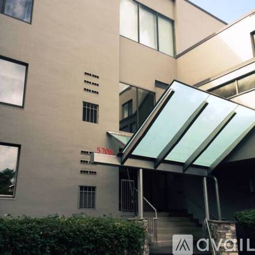 A modern building with a glass roof and stairs leading to the entrance.