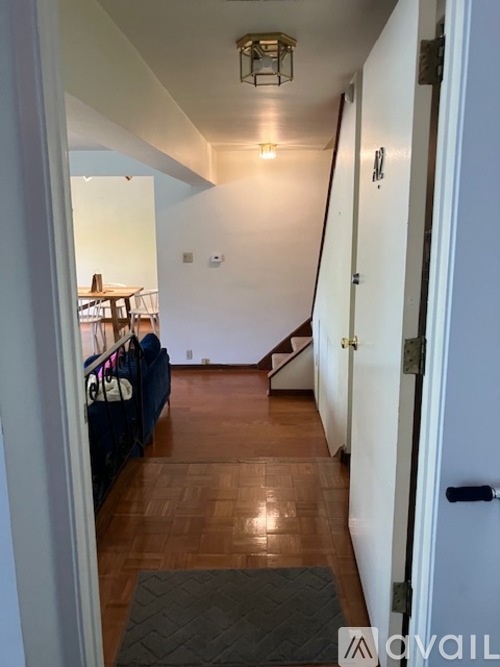 A hallway with a light on the ceiling and a mat on the floor.