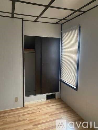 A room with wooden floors and a large closet with a sliding door.