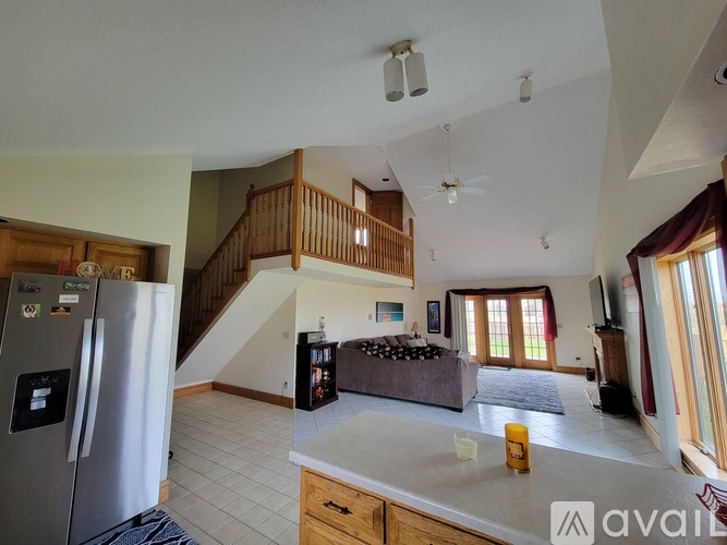 A kitchen with a refrigerator and a staircase.