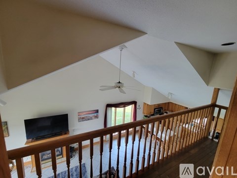 A living room with a television and a fan on the ceiling.
