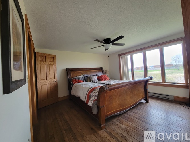 A bedroom with a large bed and a ceiling fan.
