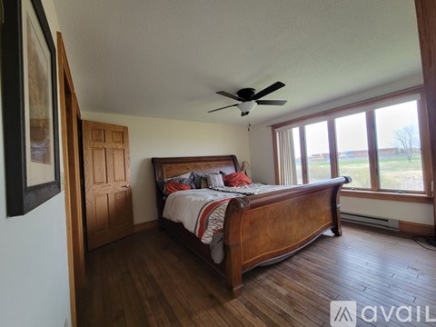 A bedroom with a large bed and a ceiling fan.