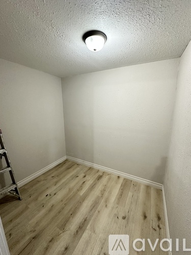 A room with a wooden floor and a ladder.