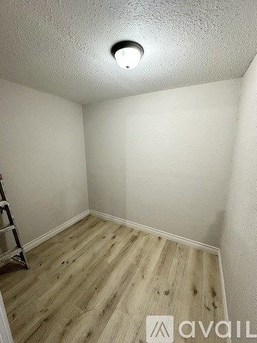 A room with a wooden floor and a ladder.