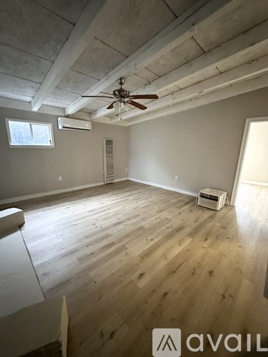A room with wooden floors and a ceiling fan.