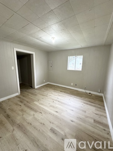 A room with wooden flooring and a window.