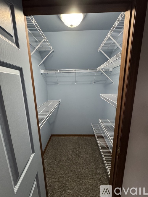 A small, empty walk-in closet with a light on.