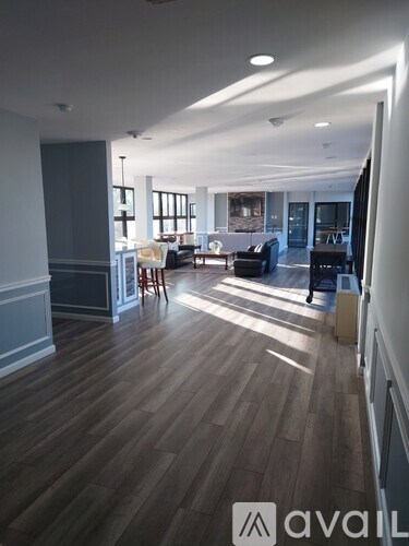 A spacious living room with wooden floors and furniture.
