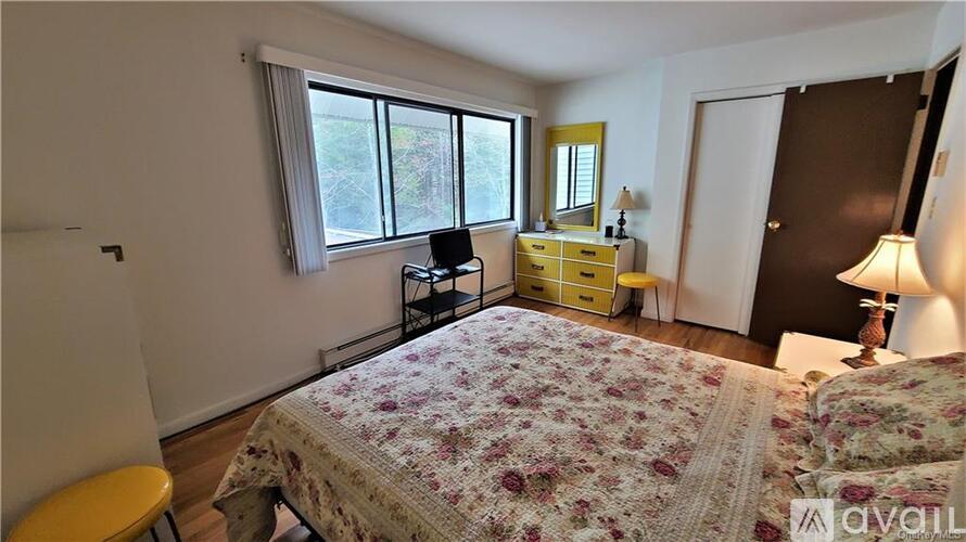 A bedroom with a floral bedspread and a yellow chair.