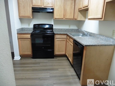 A black oven in a kitchen with wooden cabinets.