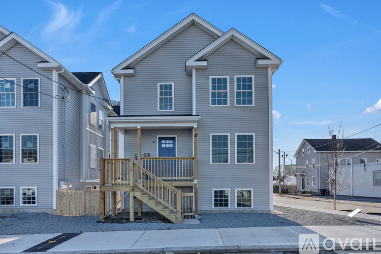 A house with a wooden deck in front of it.