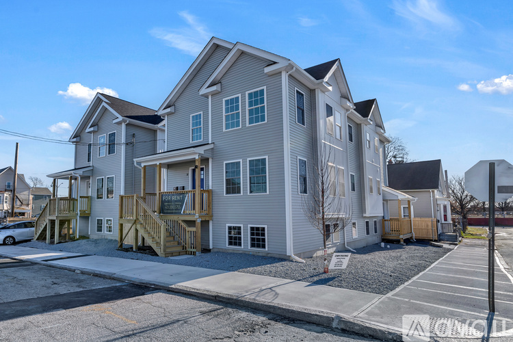 A row of houses with a car parked in front of them.