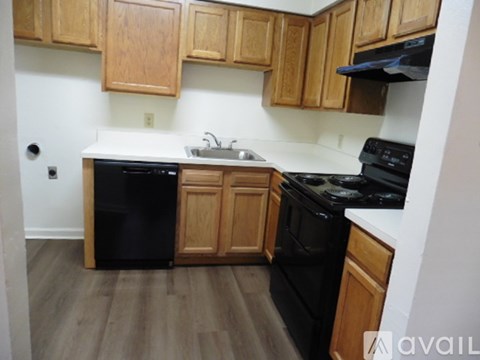 A kitchen with wooden cabinets and black appliances.