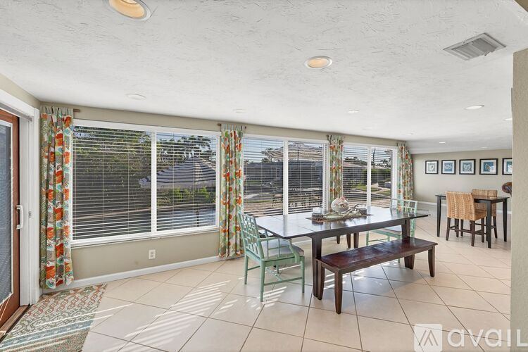 A dining room with a table set for four and a view of the backyard.