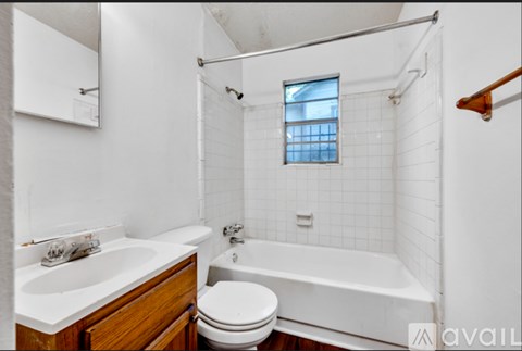 A white bathroom with a toilet, sink, and bathtub.