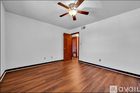 A room with a wooden floor and a ceiling fan.