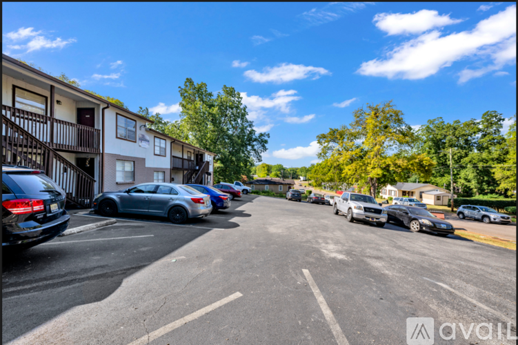 A parking lot with cars parked in front of a building with the logo "avail" on it.