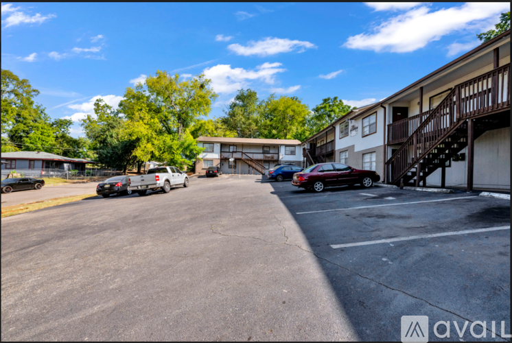 A parking lot with cars and apartment buildings in the background.